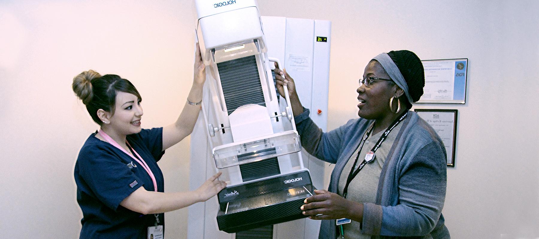 two women working with a mammography machine